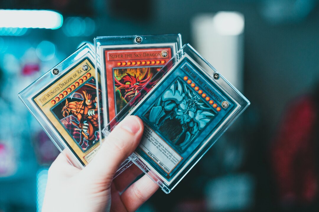 3 Cartes Yu-Gi-Oh protégées dans une main